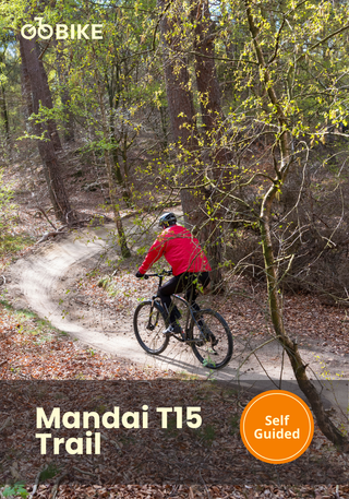 Person riding a bike on a trail with 'Mandai T15 Trail' branding and 'Self Guided' label.
