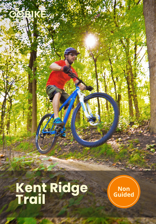 Person riding a mountain bike on Kent Ridge trail with trees in the background.
