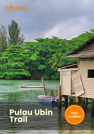 Scenic view of a wooden house by a body of water with greenery, featuring the Pulau Ubin Trail.