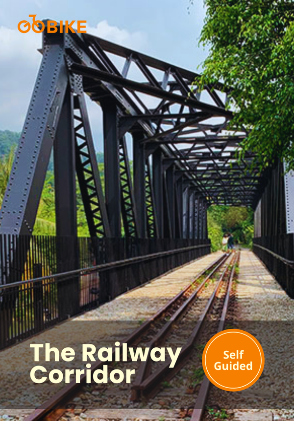 Cycling route along the black iron bridge on Singapore’s Railway Corridor trail through lush greenery