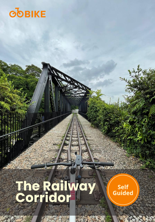 Bicycle on railway tracks with a bridge along Singapore’s Railway Corridor cycling trail