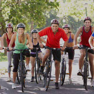 Group of people riding bicycles outdoors on a sunny day